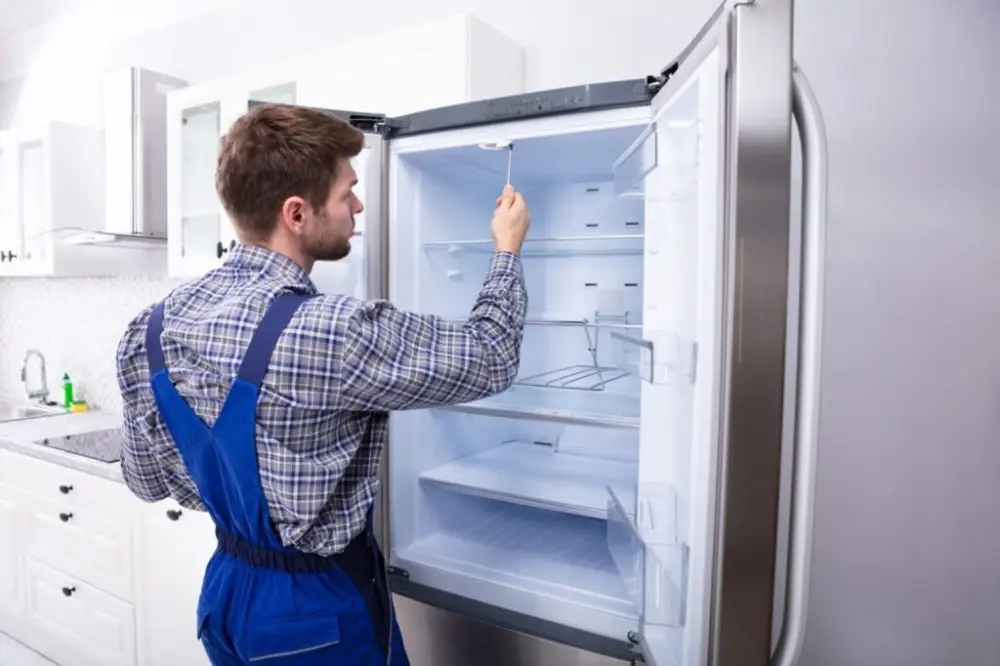мастер проверяет работу промышленного холодильника